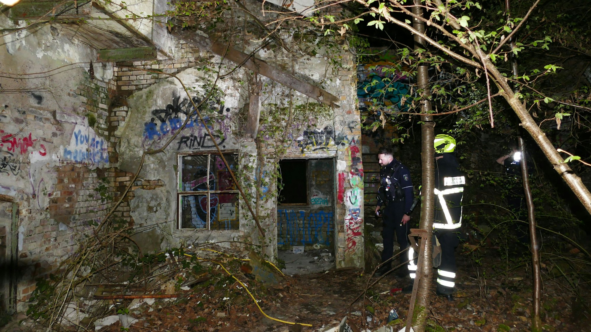 Rettungskräfte im Wald vor der Ruine des Pleistalswerks, wo der Jugendliche vermutlich abgestürzt war.