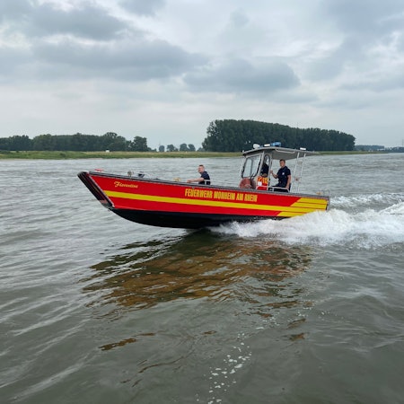 Einsatzkräfte der Feuerwehr auf dem Rhein bei Monheim im Einsatz.