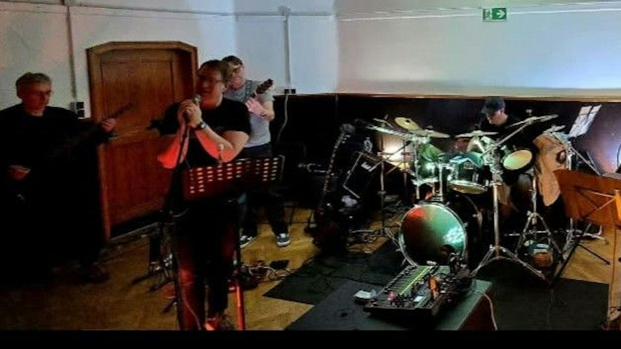 Eine Band spielt Schlagzeug, Bass und Gitarre.