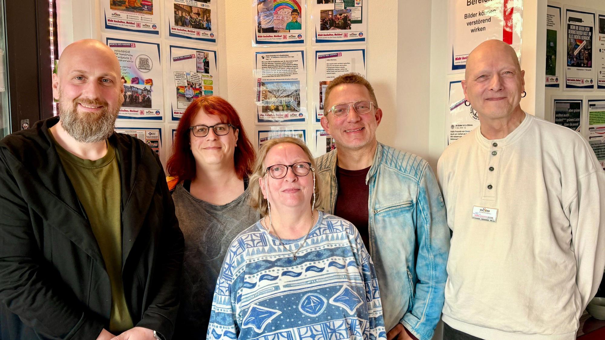 Mitglieder des Vereins Queer Euskirchen stehen vor einer der Wände, an denen die positiven Feedbacks und Solidaritätsbekundungen hängen.