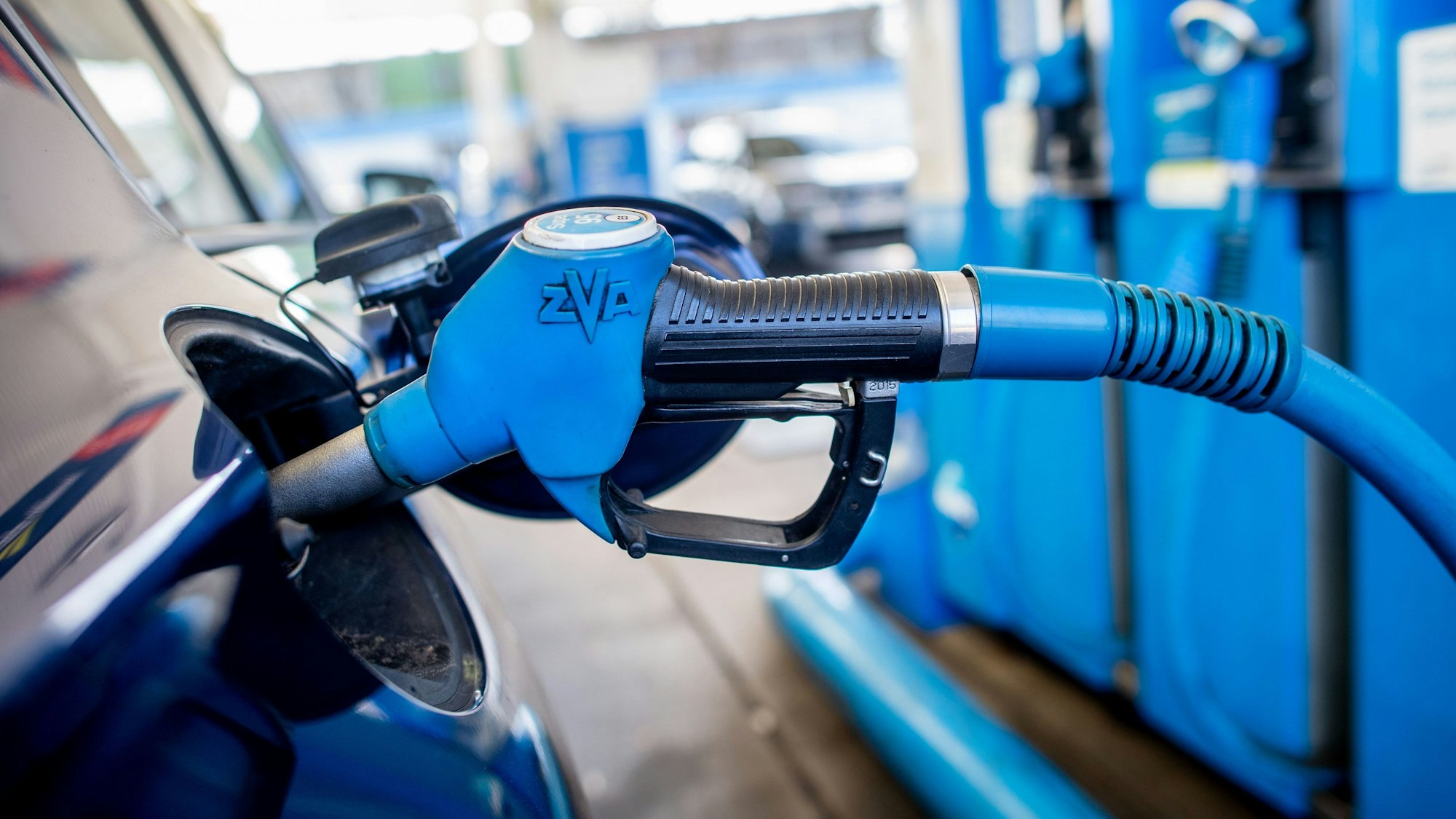 Eine Zapfpistole mit der Aufschrift „Super 95“ steckt an einer Tankstelle in der Tanköffnung eines Fahrzeugs. (Archivbild)