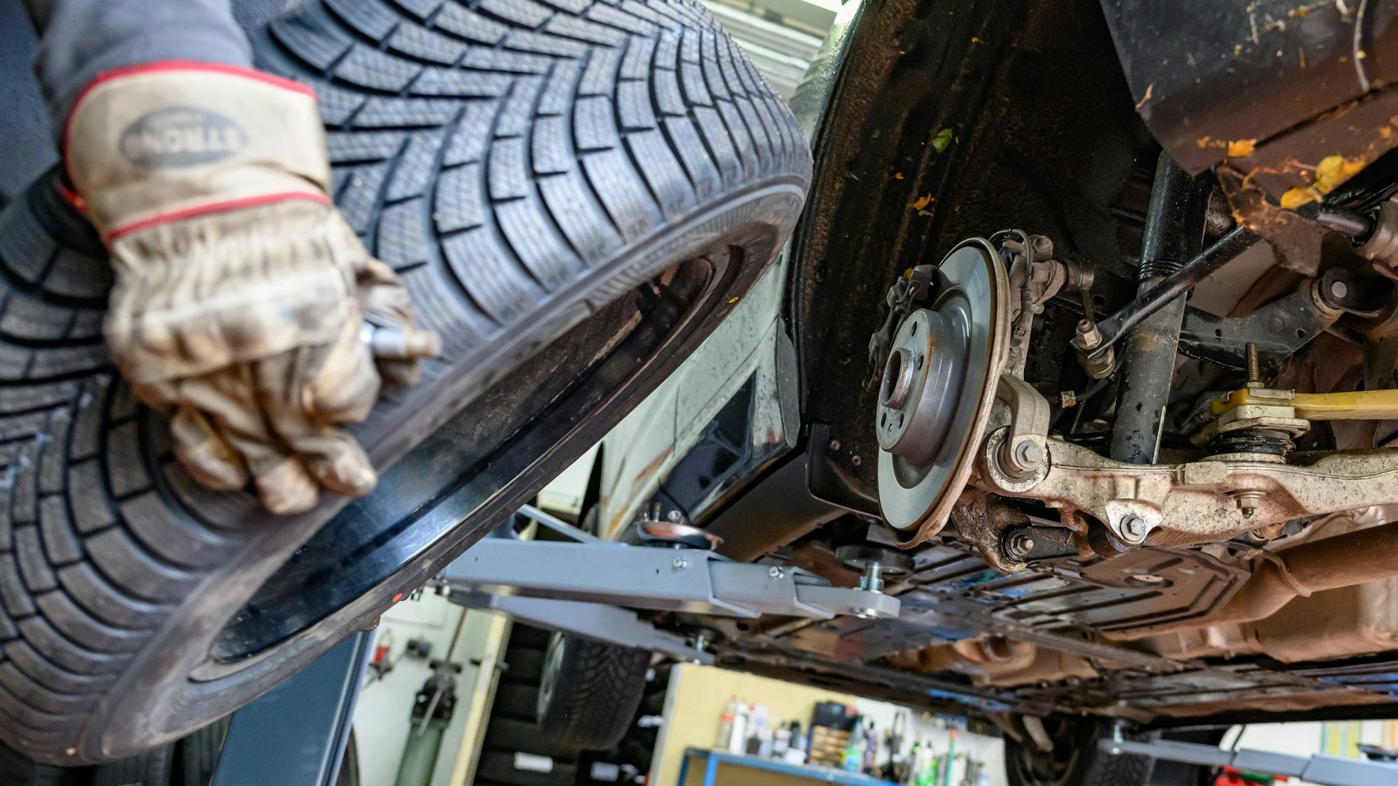 Ein Reifen wird in einer Werkstatt an ein Auto montiert