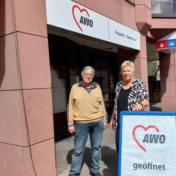 Udo Schumpe und Birgit Biegel stehen nebeneinander hinter einem Aufsteller, der auf das Awo-Zentrum hinweist.