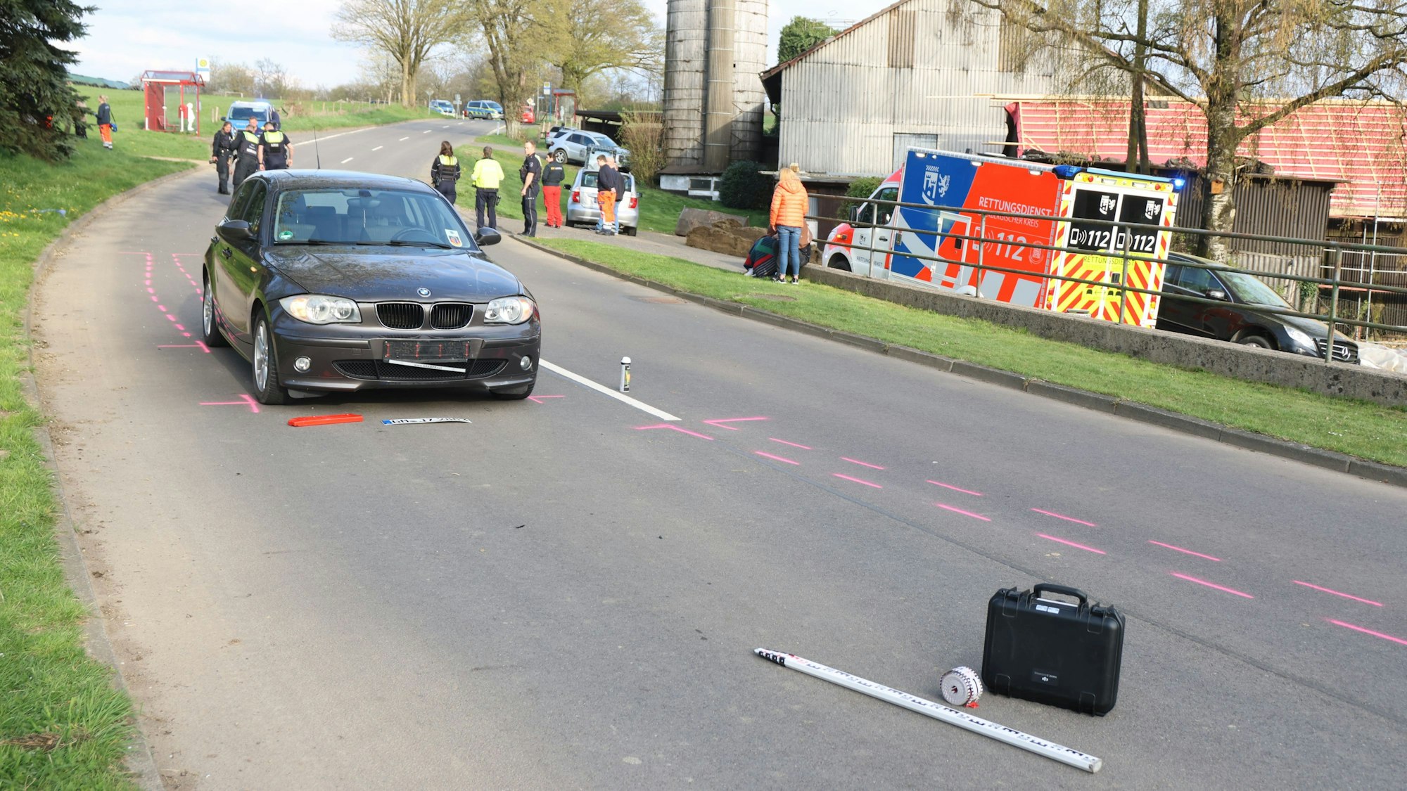 Ein schwarzer Bmw steht auf der Straße. Am Rand steht ein Rettungswagen.