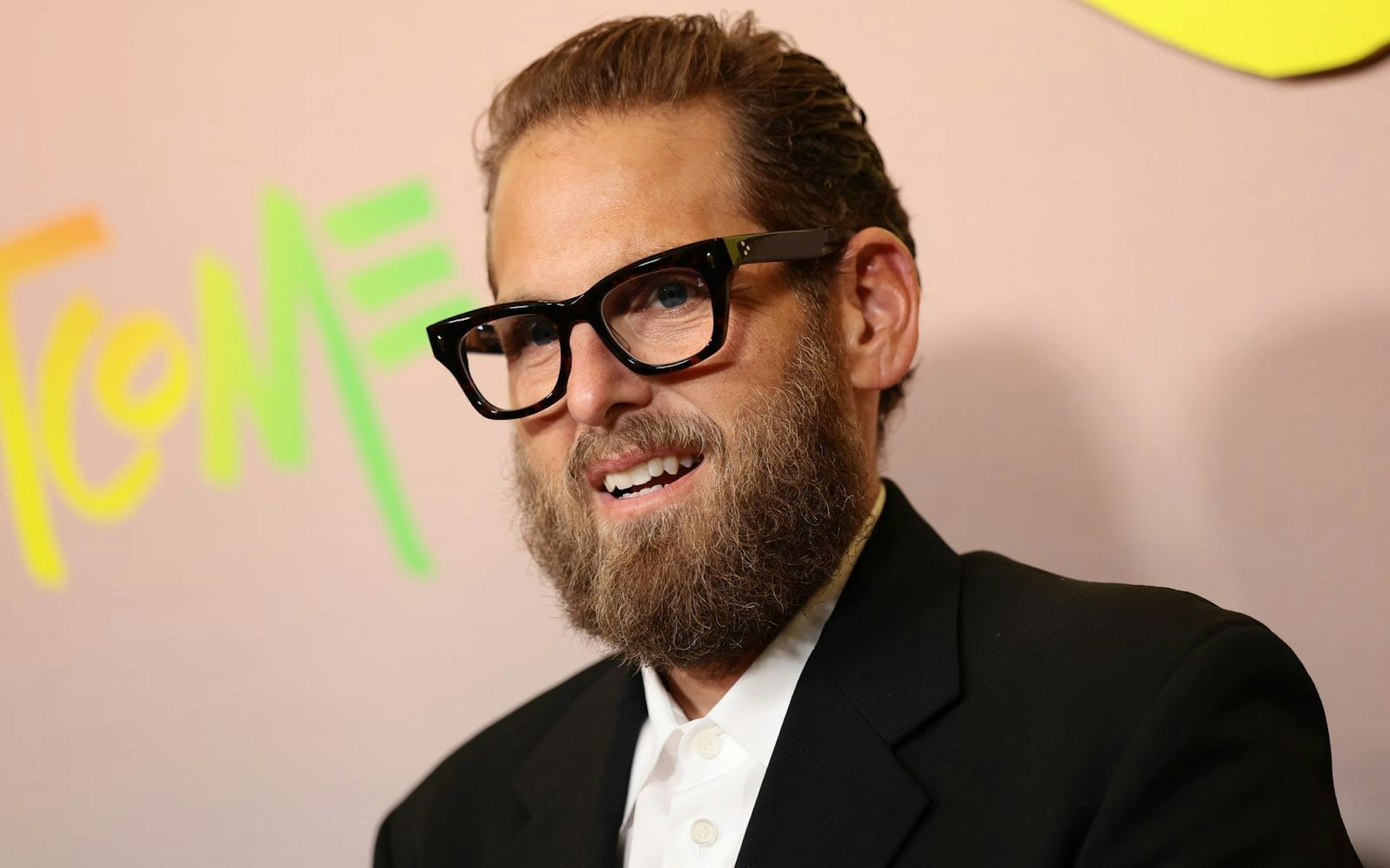So kennt man US-Schauspieler Jonah Hill: Mit schwarzer Brille, zurückgestylten Haaren und einem Bart. (Bild: 2026 Getty Images/Dimitrios Kambouris)