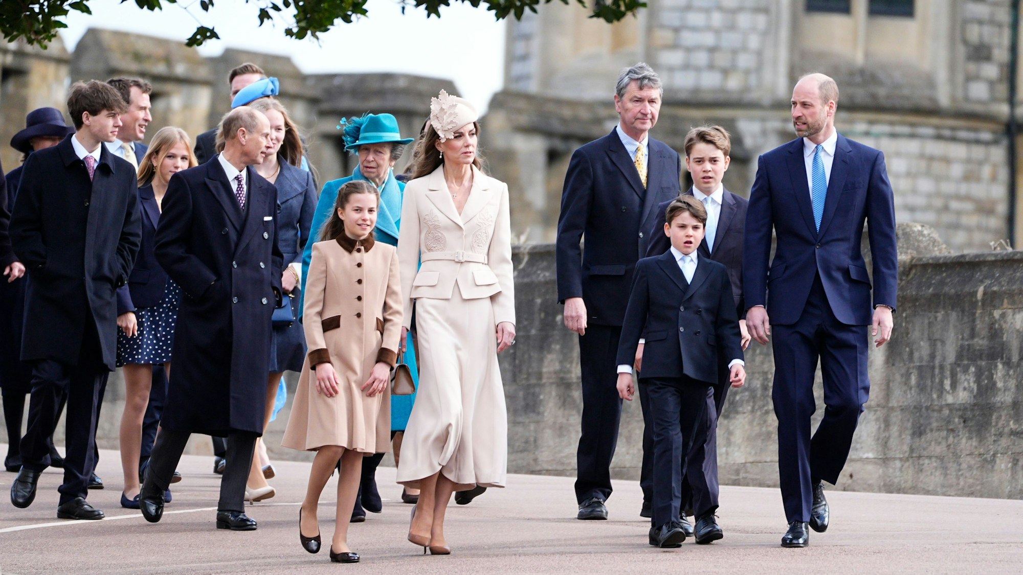 Prinzessin Kate (M) und Prinz William (r) kommen mit ihren Kindern Prinz George, Prinzessin Charlotte und Prinz Louis (vorne r) gemeinsam (M,l) mit weiteren Mitgliedern der königlichen Familie zum Ostergottesdienst in der St. George’s Chapel.