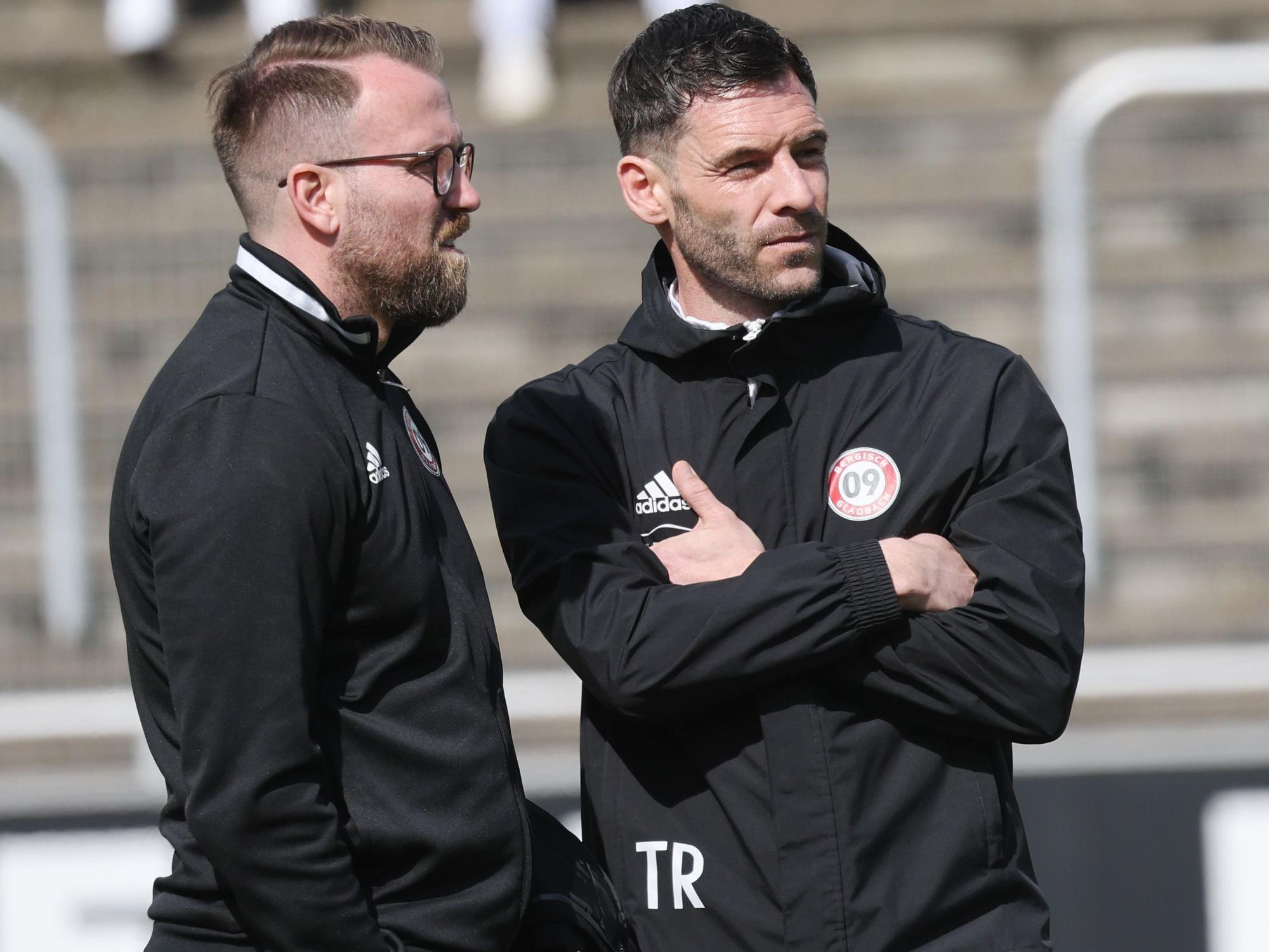 Christian Schlösser und Kevin Kruth stehen zusammen am Spielfeldrand.