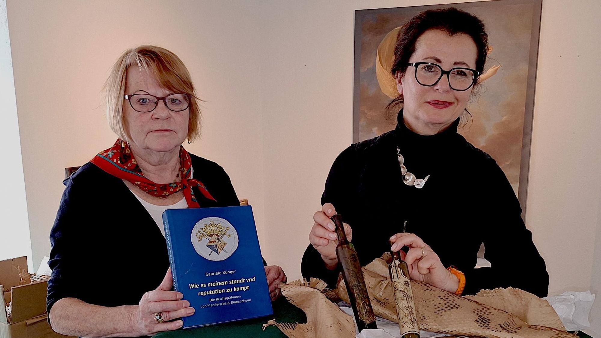 Zwei Frauen präsentieren das Buch und zwei Reiseflakons.