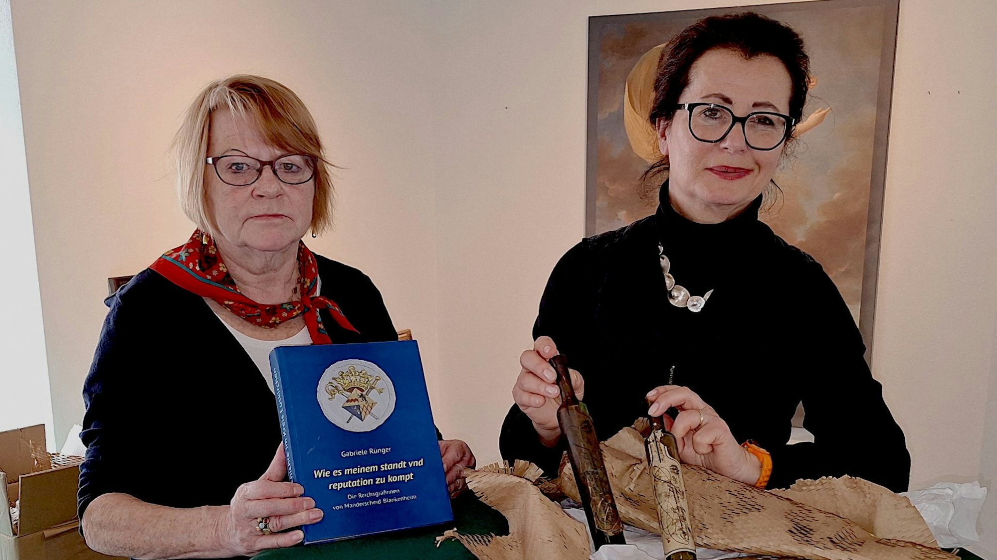 Zwei Frauen präsentieren das Buch und zwei Reiseflakons.