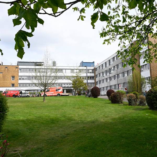 Ein graues Klinikgebäude, vorne ein grüner Rasen