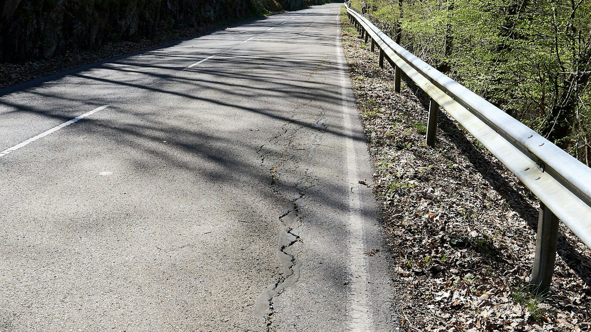 Auf der rechten Seite der Fahrbahn der L249 in der Stadt Heimbach sind Risse zu erkennen. Sie sind ein Zeichen dafür, dass der Untergrund nicht mehr stabil ist.