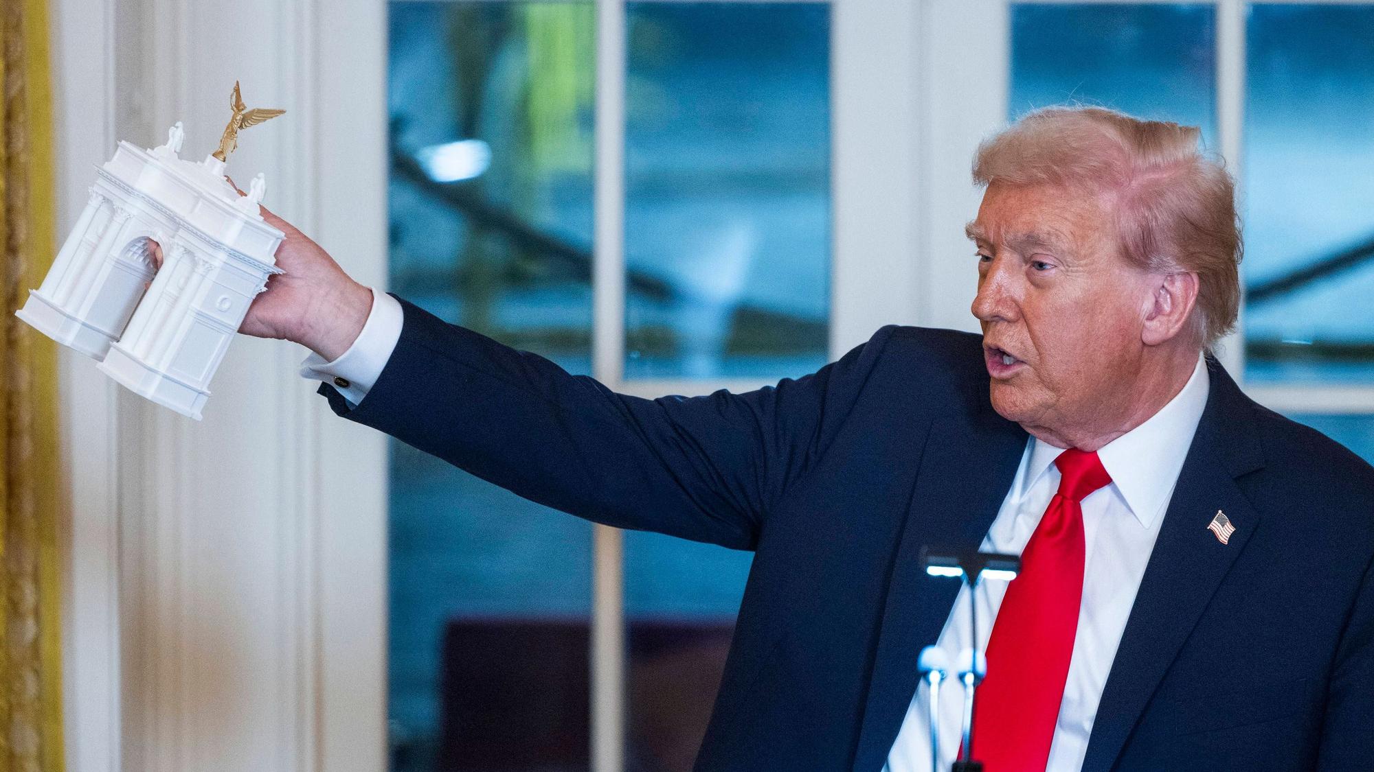 US-Präsident Donald Trump zeigt bei einem Abendessen für Spender, die zum Bau des neuen Ballsaals im Weißen Haus beigetragen haben, das Modell eines Triumphbogens. (Archivbild)