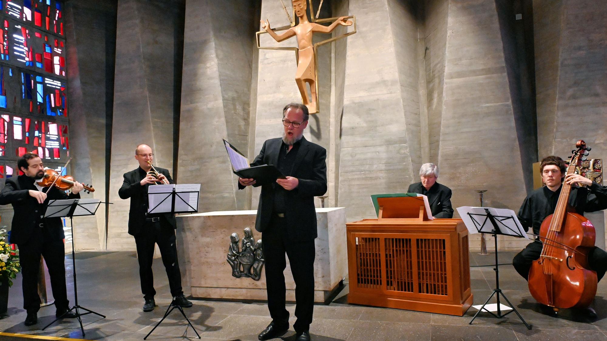 Bass-Bariton Thomas Bonni steht singend im Altarraum der Kapelle. Neben ihm stehen und sitzen vier Musiker, die ihn begleiten.