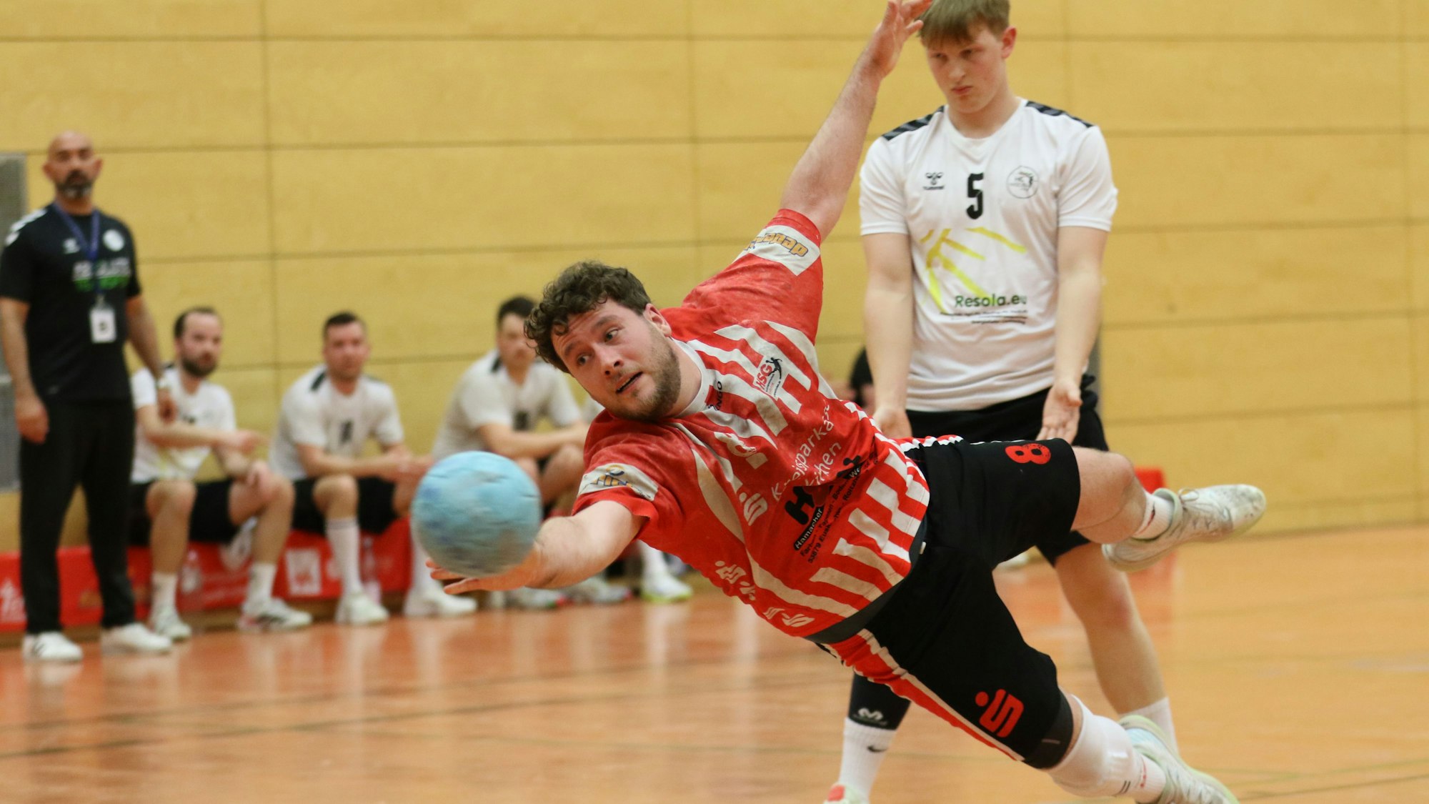 Das Bild zeigt Tobias Bünder, der quer in der Luft liegt und versucht, den Ball noch entscheidend in Richtung Tor zu bugsieren.