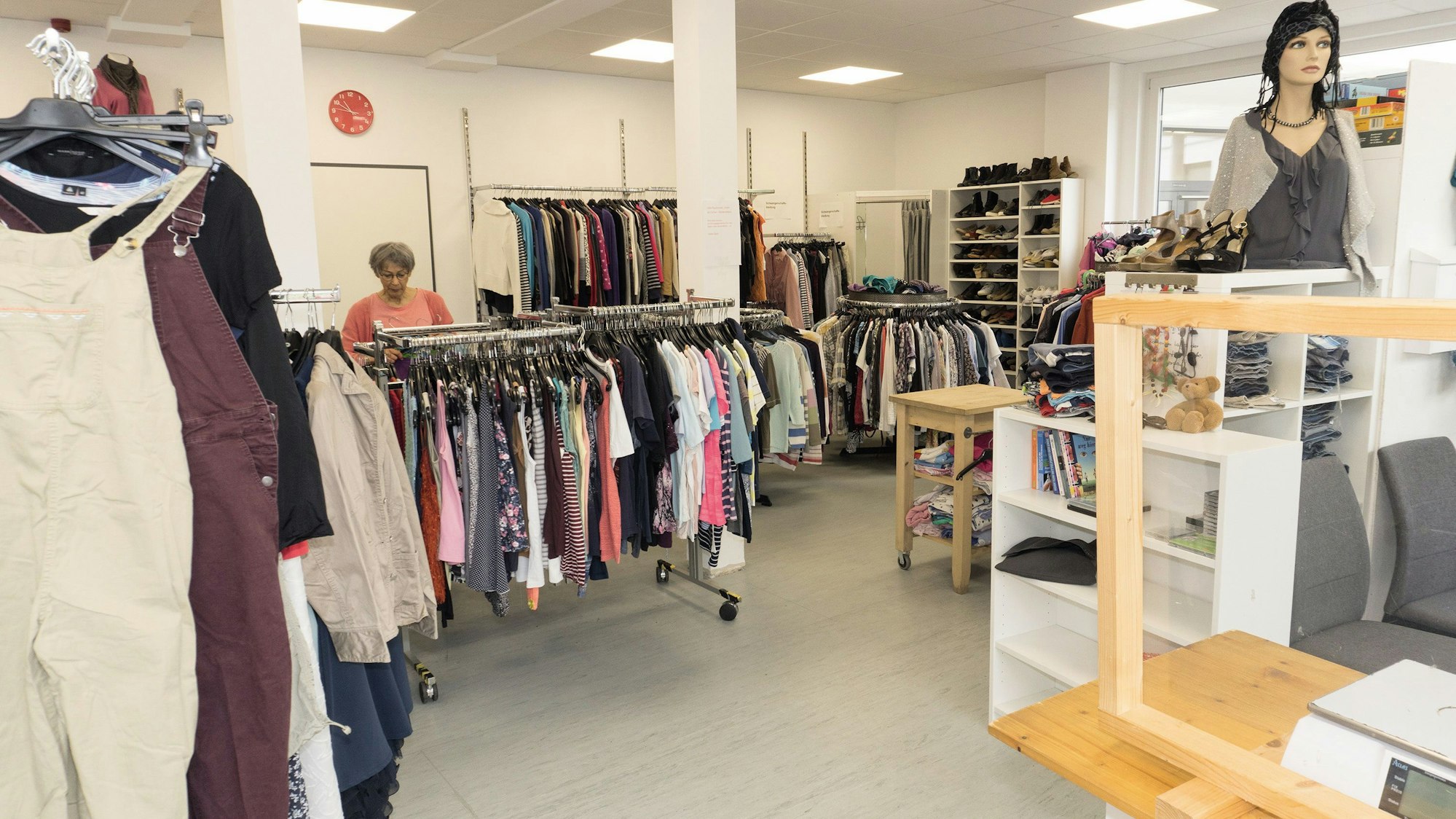 In dem Caritas-Kleiderladen hängen viele Anziehsachen an Ständern. Auch die Regale sind gefüllt mit gebrauchten Klamotten.