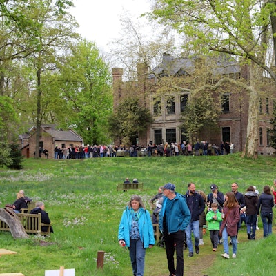 Das Foto zeigt Menschen im Garten eines Ritterguts.