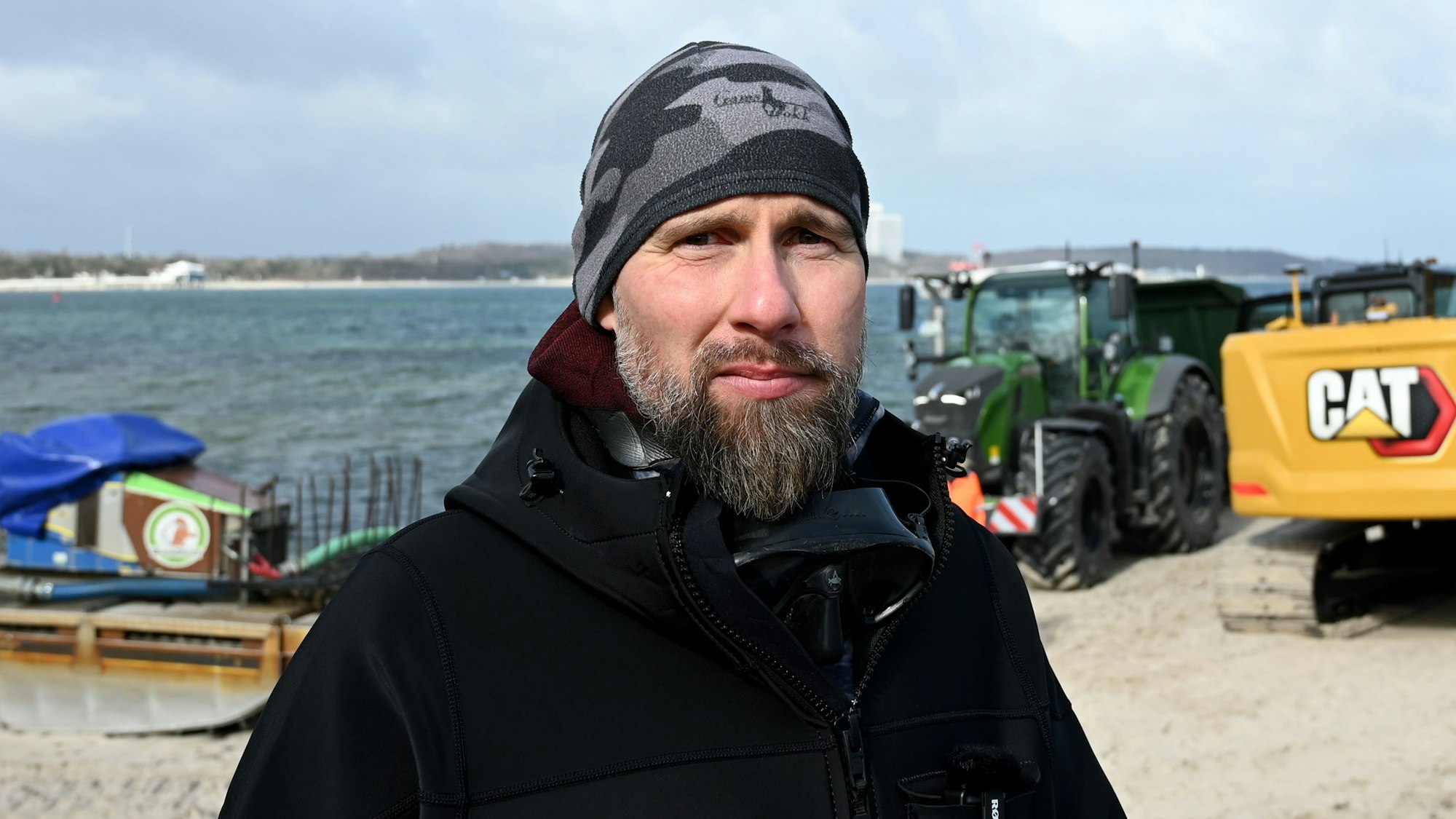 Robert Marc Lehmann, Biologe, steht in der Nähe des gestrandeten Wals in der Ostsee am Strand.