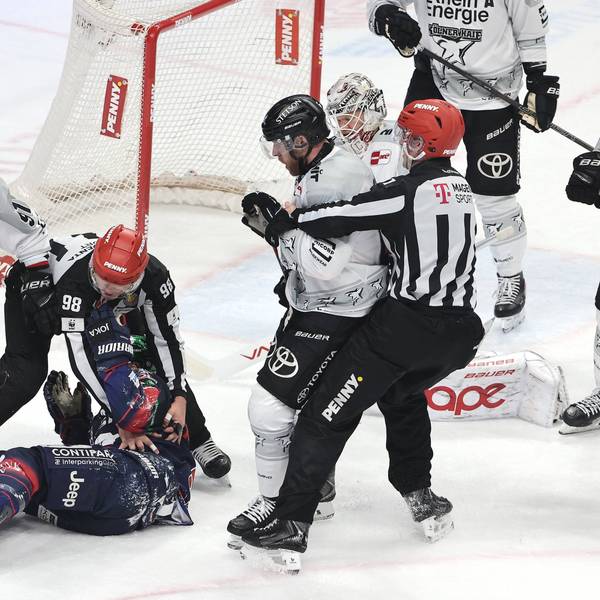 Referees schützen Berlins Ty Ronning nach Zweikampf mit Kölns Torwart Janne Juvonen.
