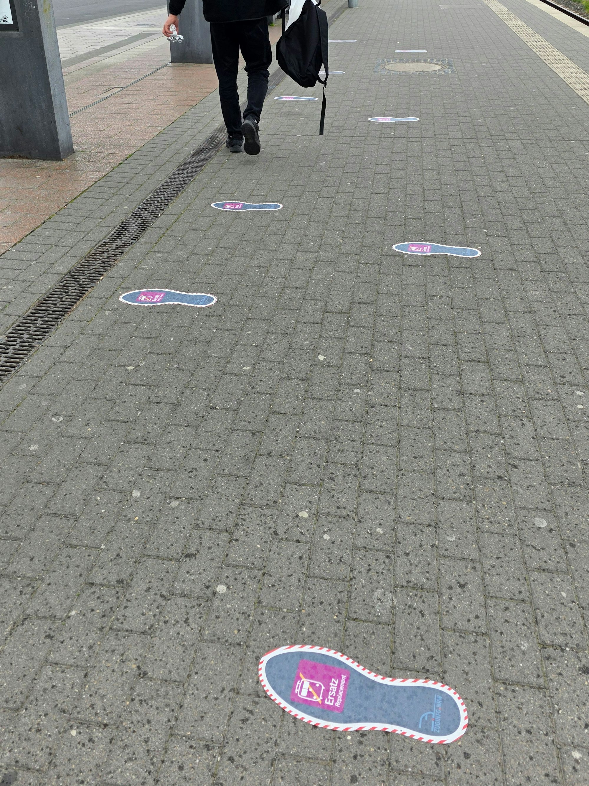 Aufgeklebte Fußstapfen auf dem Bahnsteig des Bergisch Gladbacher S-Bahnhof sollen den Weg zum Schienenersatzverkehr weisen.