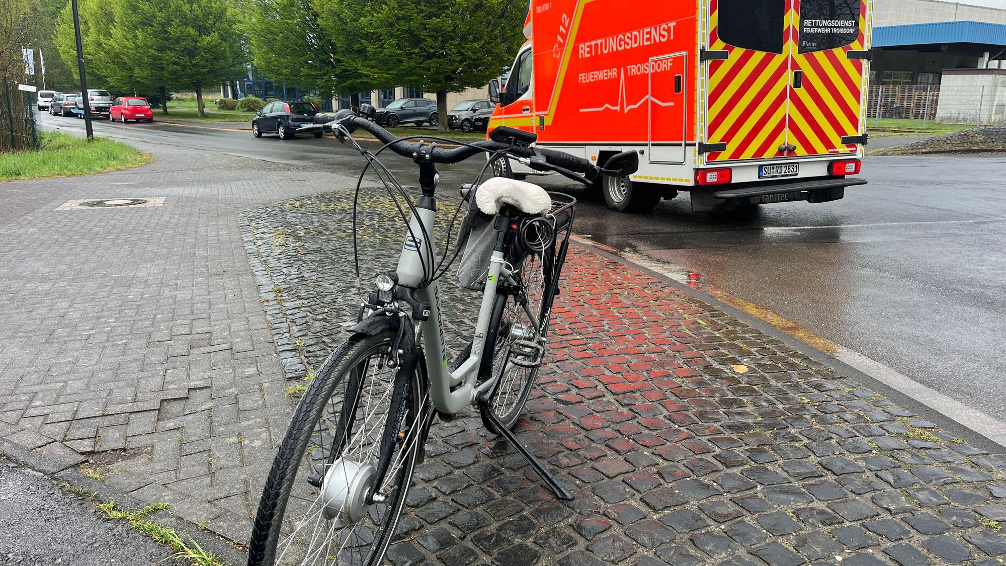 Eine 83 Jahre alte Radfahrerin aus Troisdorf wird nach dem Unfall in einem Rettungswagen behandelt.