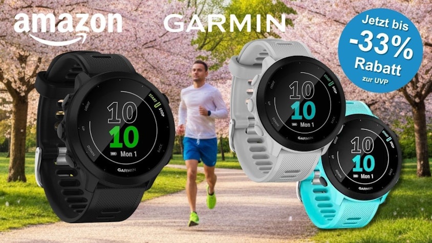 Drei Modelle der Garmin Forerunner 55 GPS-Laufuhr in den Farben Schwarz, Weiss und Mint vor einem joggenden Mann in einem Frühlingspark mit blühenden Bäumen. Amazon- und Garmin-Logo.