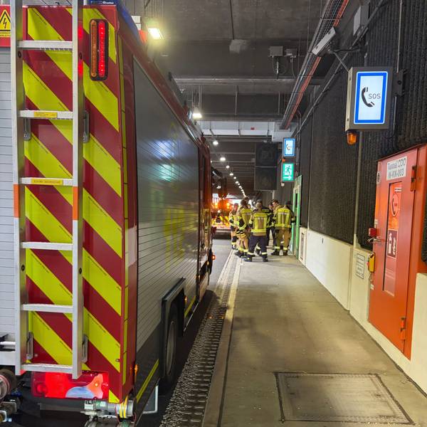 Ein Feuerwehrfahrzeug und Feuerwehrleute in einem Tunnel.