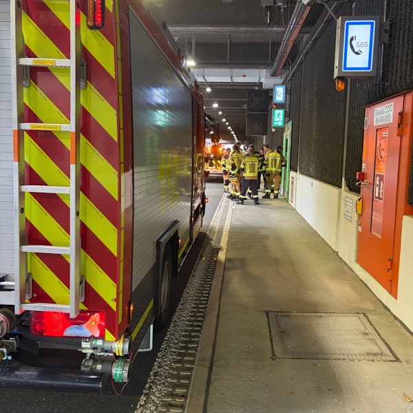 Ein Feuerwehrfahrzeug und Feuerwehrleute in einem Tunnel.