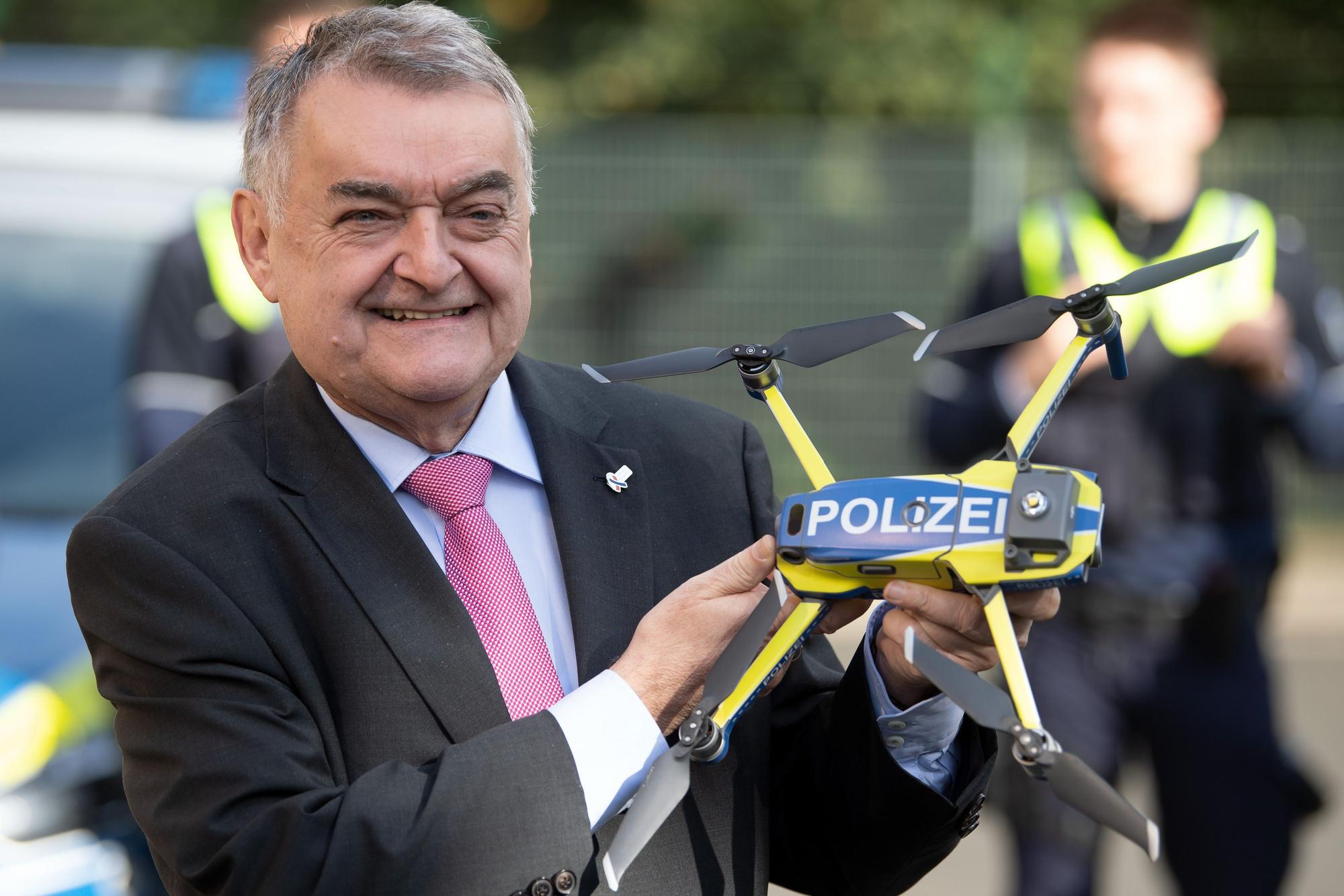 12.10.2020, Nordrhein-Westfalen, Neuss: Herbert Reul (CDU), Innenminister von Nordrhein-Westfalen, hält eine Drohne für die Polizei in den Händen. Nach einer Pilotphase gehen Drohnen in der nordrhein-westfälischen Polizei in den regulären Einsatz. Foto: Federico Gambarini/dpa +++ dpa-Bildfunk +++