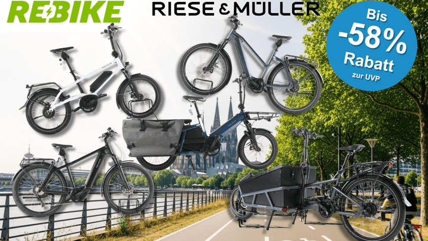 4 verschiedene Riese & Müller E-Bikes vor einem Fahrradweg am Waldran neben einem Fluss.
