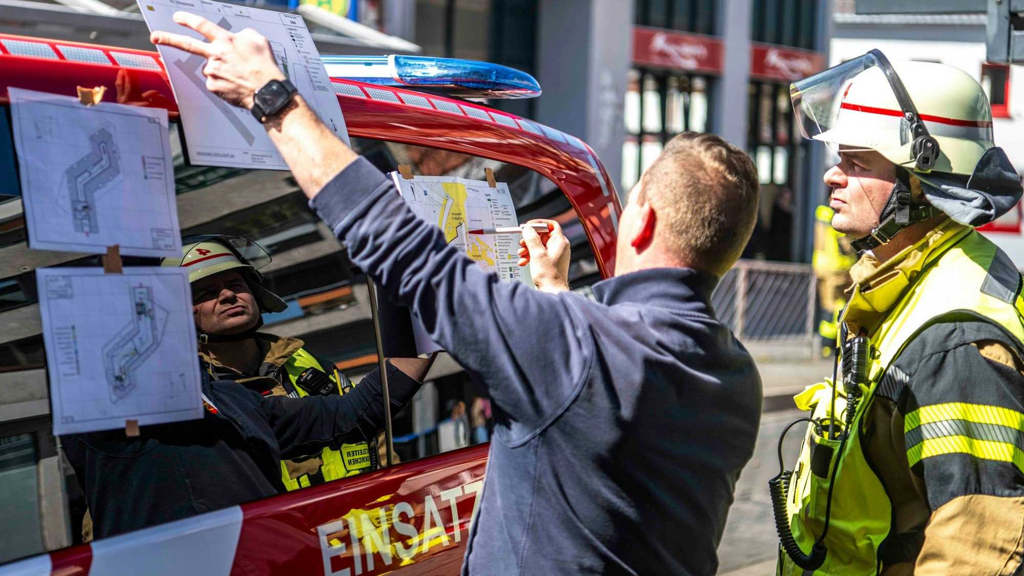 Das Bild zeigt Einsatzleiter Martin Dauben, der sich den Grundriss des Gebäudes erklären lässt.