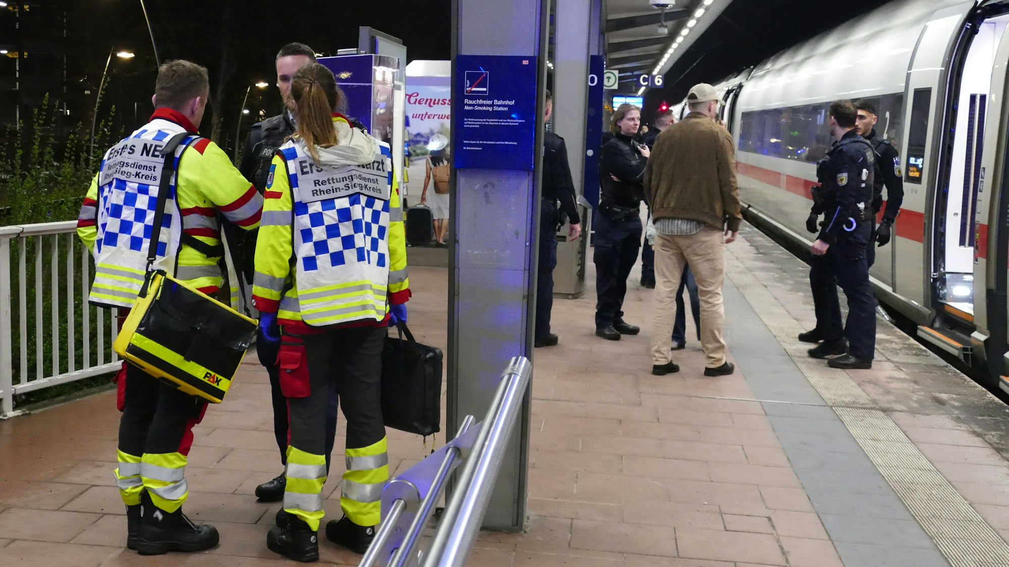 Rettungskräfte und Bundespolizisten stehen am Abend des 3. April am ICE-Bahnhof Siegburg/Bonn an dem ICE, in dem ein 20 jahre alter Mann zwei Sprengvorrichtugnen gezündet hatte.