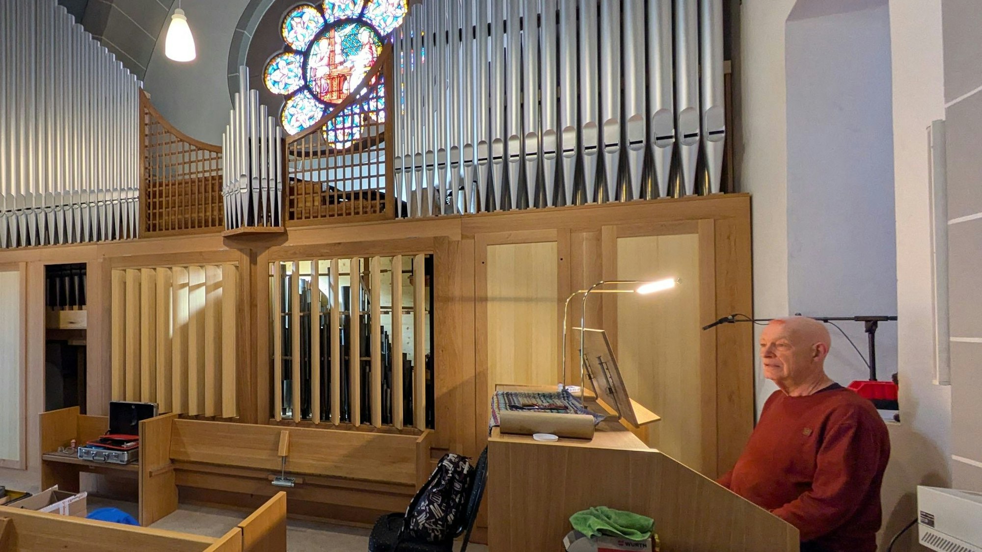 Ein Mann sitzt an einer Orgel in einer Kirche.