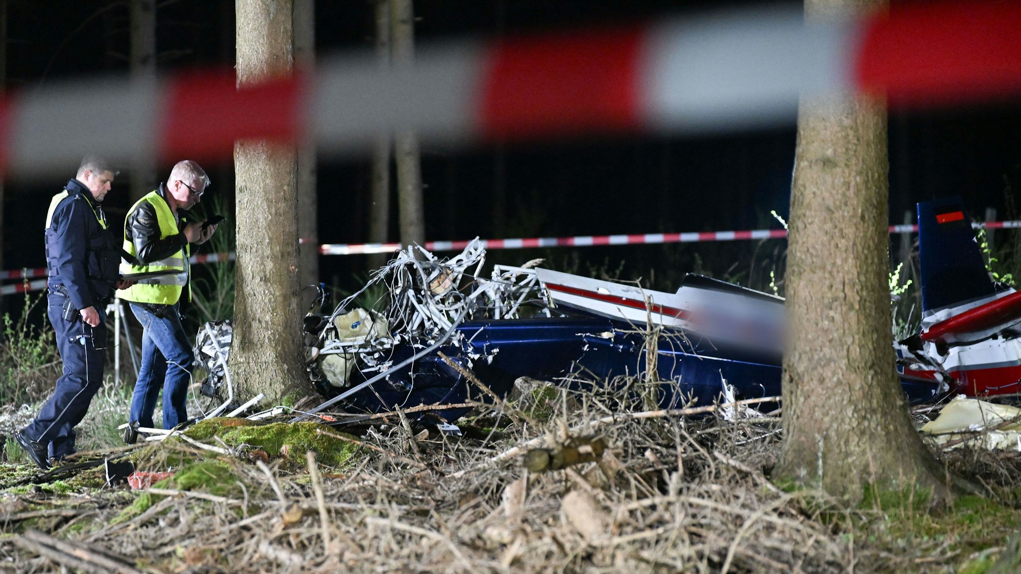 Einsatzkräfte untersuchen ein abgestürztes Kleinflugzeug bei Hürtgenwald. Beim Absturz eines Kleinflugzeugs im Kreis Düren (Nordrhein-Westfalen) sind die beiden Insassen gestorben.