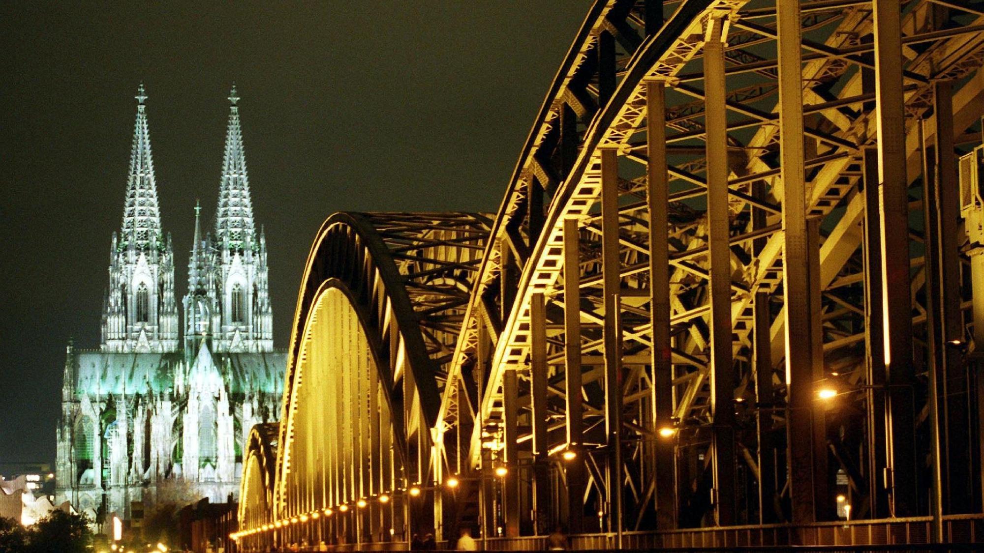 Kölner Dom und Hohenzollernbrücke nachts angestrahlt.