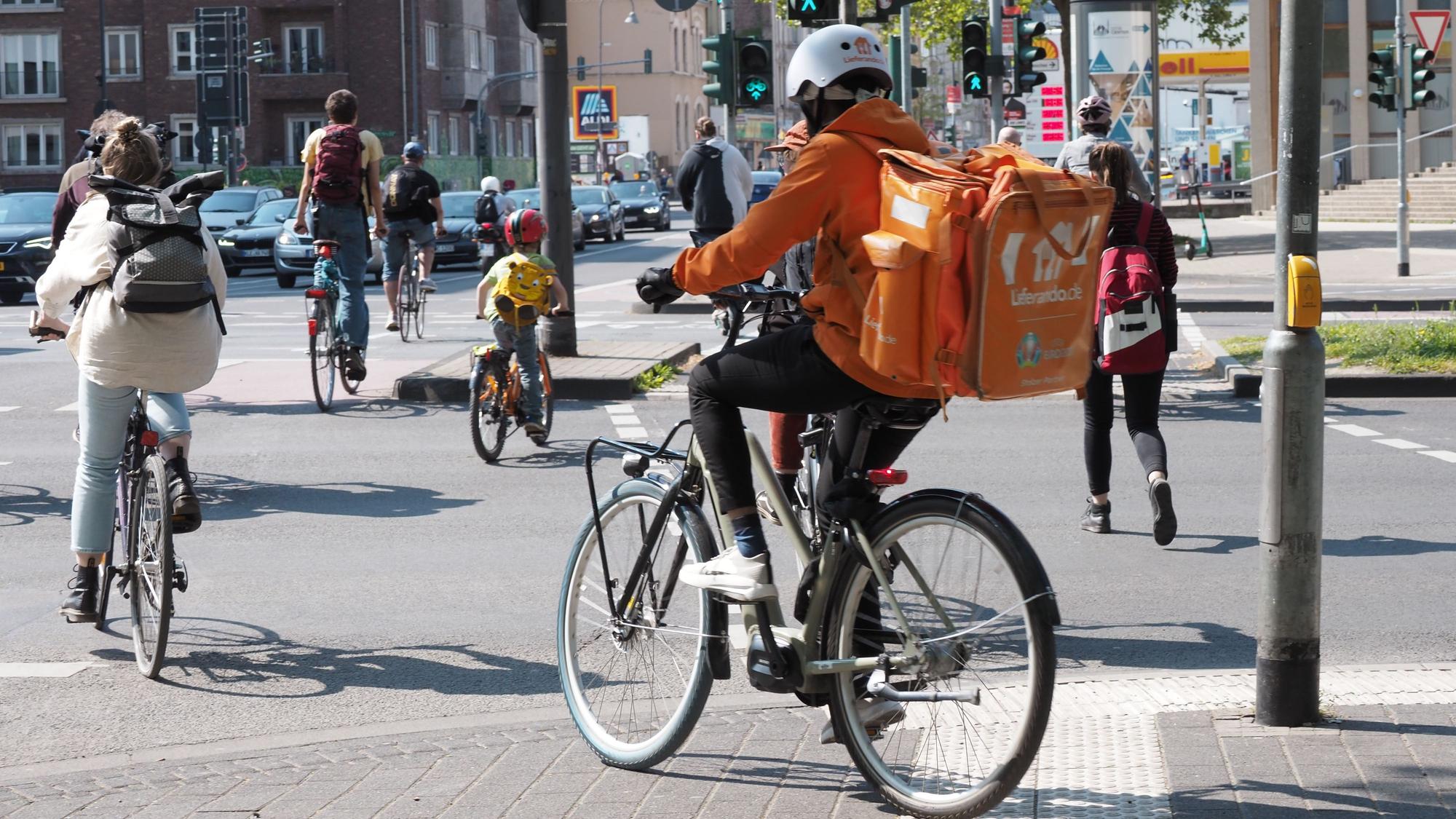 03.05.2022, Köln: Ehrenfeld, LieferandoRadfahrer an der Venloer Straße stadtauswärts, Höhe Innere Kanalstraße. Foto: Max Grönert