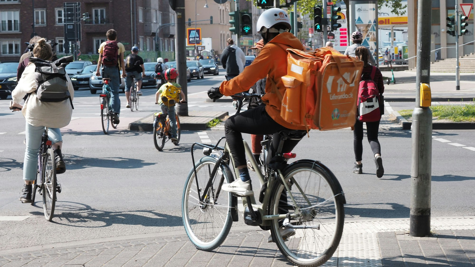 03.05.2022, Köln: Ehrenfeld, LieferandoRadfahrer an der Venloer Straße stadtauswärts, Höhe Innere Kanalstraße. Foto: Max Grönert