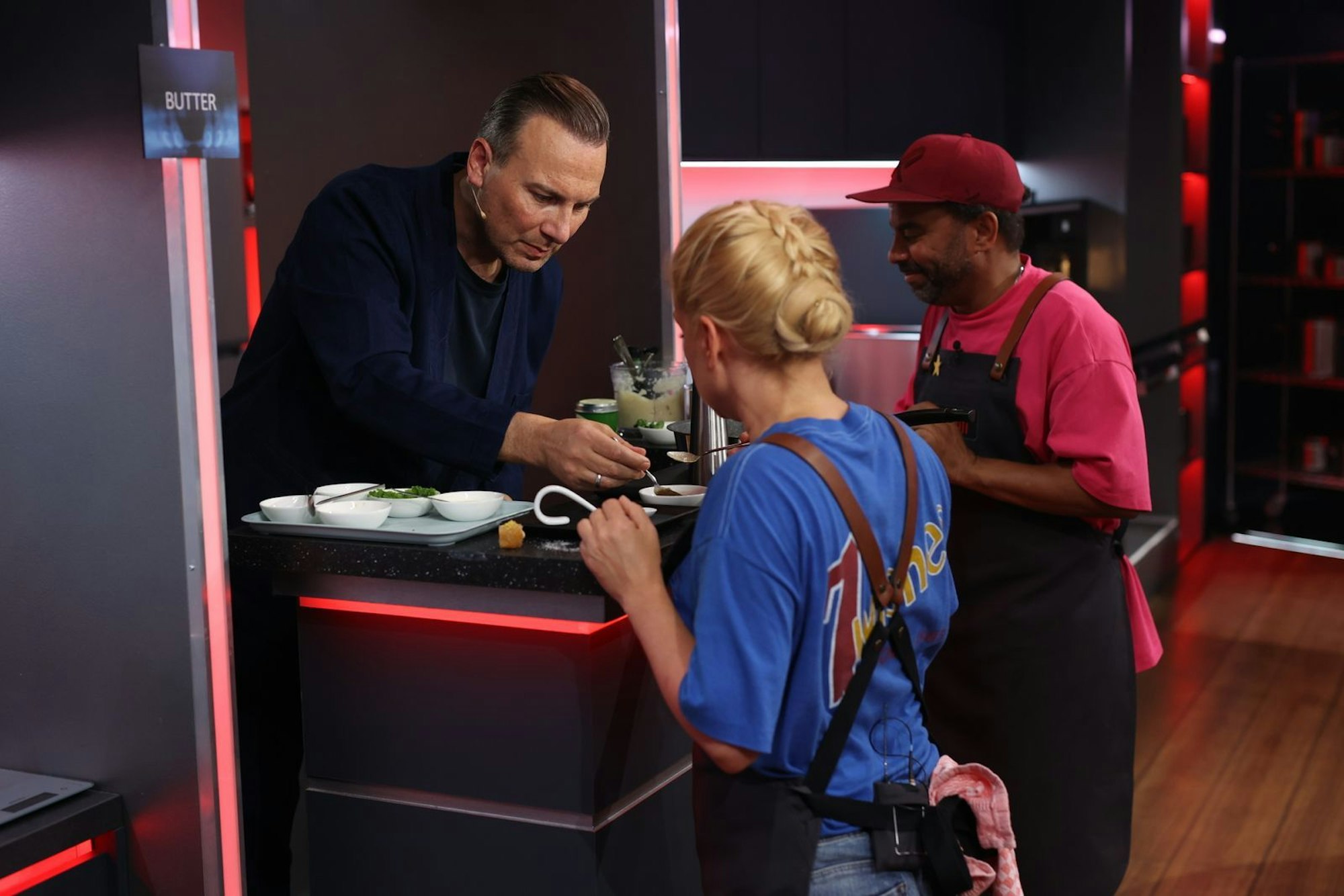Tim Raue gibt Jeanette Biedermann und Simon Pearce klare Ansagen. (Bild: Joyn/ Benedikt Müller)
