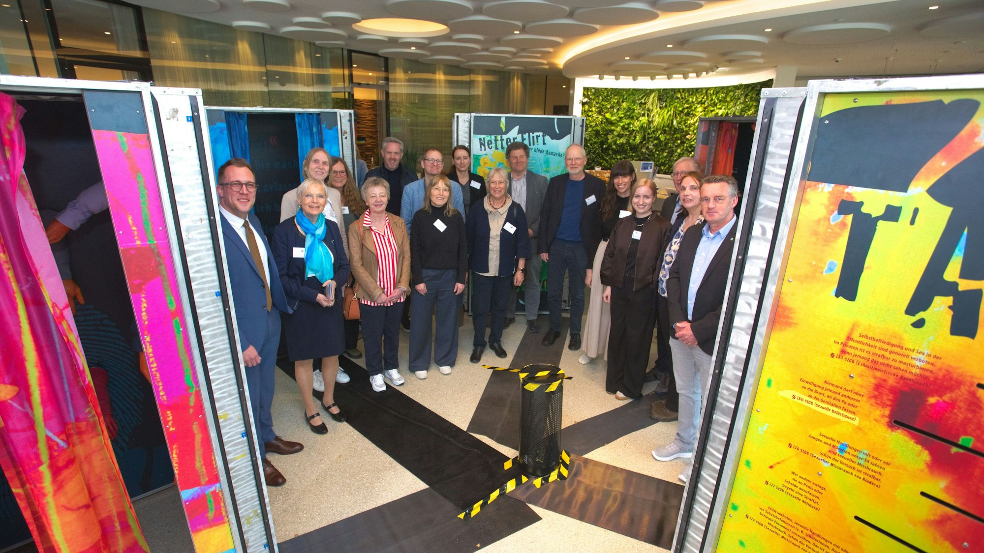 Eine Gruppe von Menschen zwischen Stellwänden.