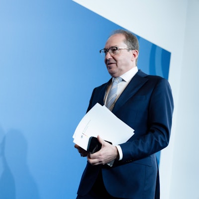 Alexander Dobrindt hält Papiere im Anzug