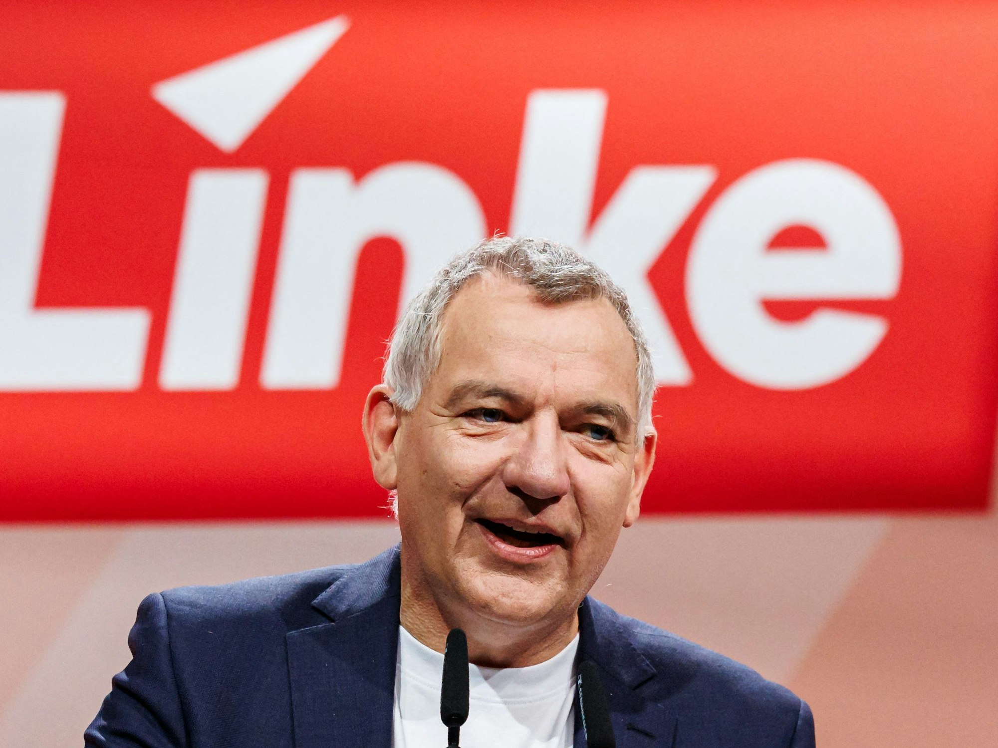 Jan van Aken spricht in ein Mikrofon.