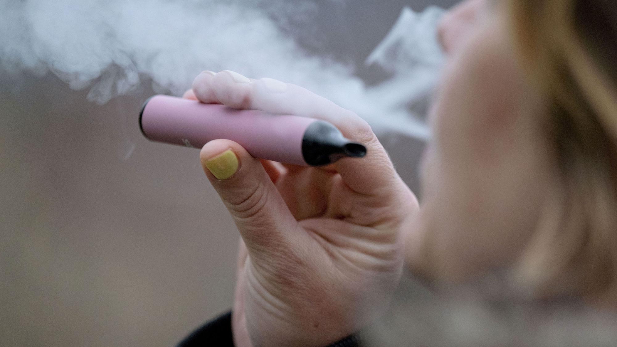 Eine Frau raucht eine E-Zigarette. Nichtraucherschutz soll in NRW zukünftig auch bei E-Zigaretten und Cannabis gelten.