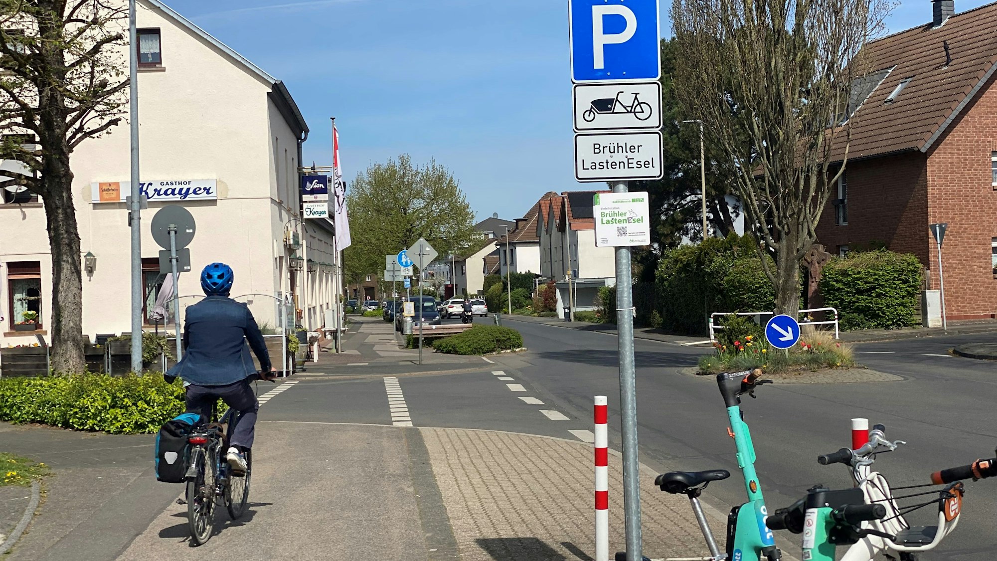 Zu sehen ist ein Radler, der entlang einer Straße fährt.