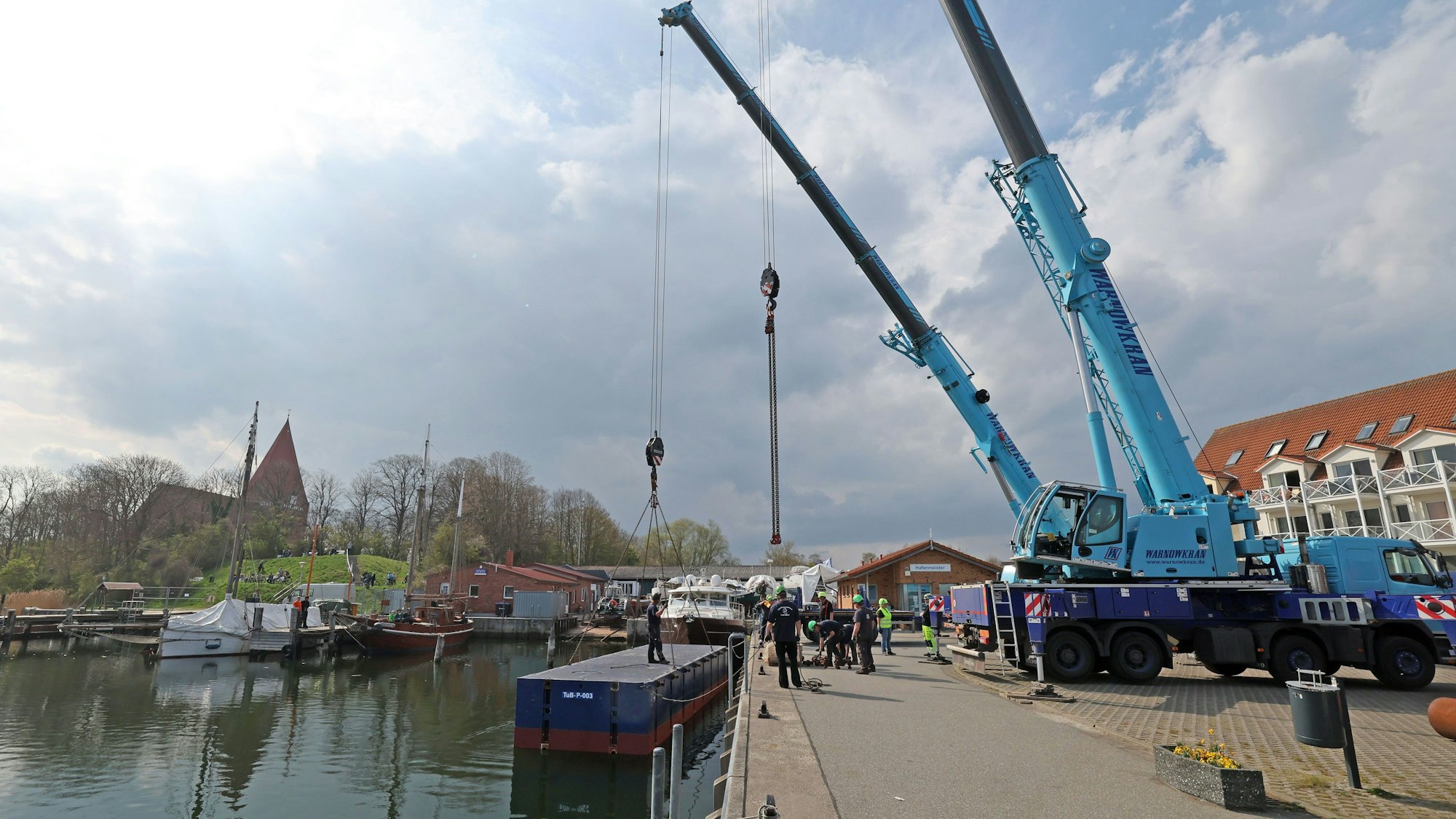 Im Hafen von Kirchdorf auf der Ostseeinsel Poel werden die vier Teile für die Pontons zur Rettung des gestrandeten Buckelwals mit Kränen ins Wasser gehoben.