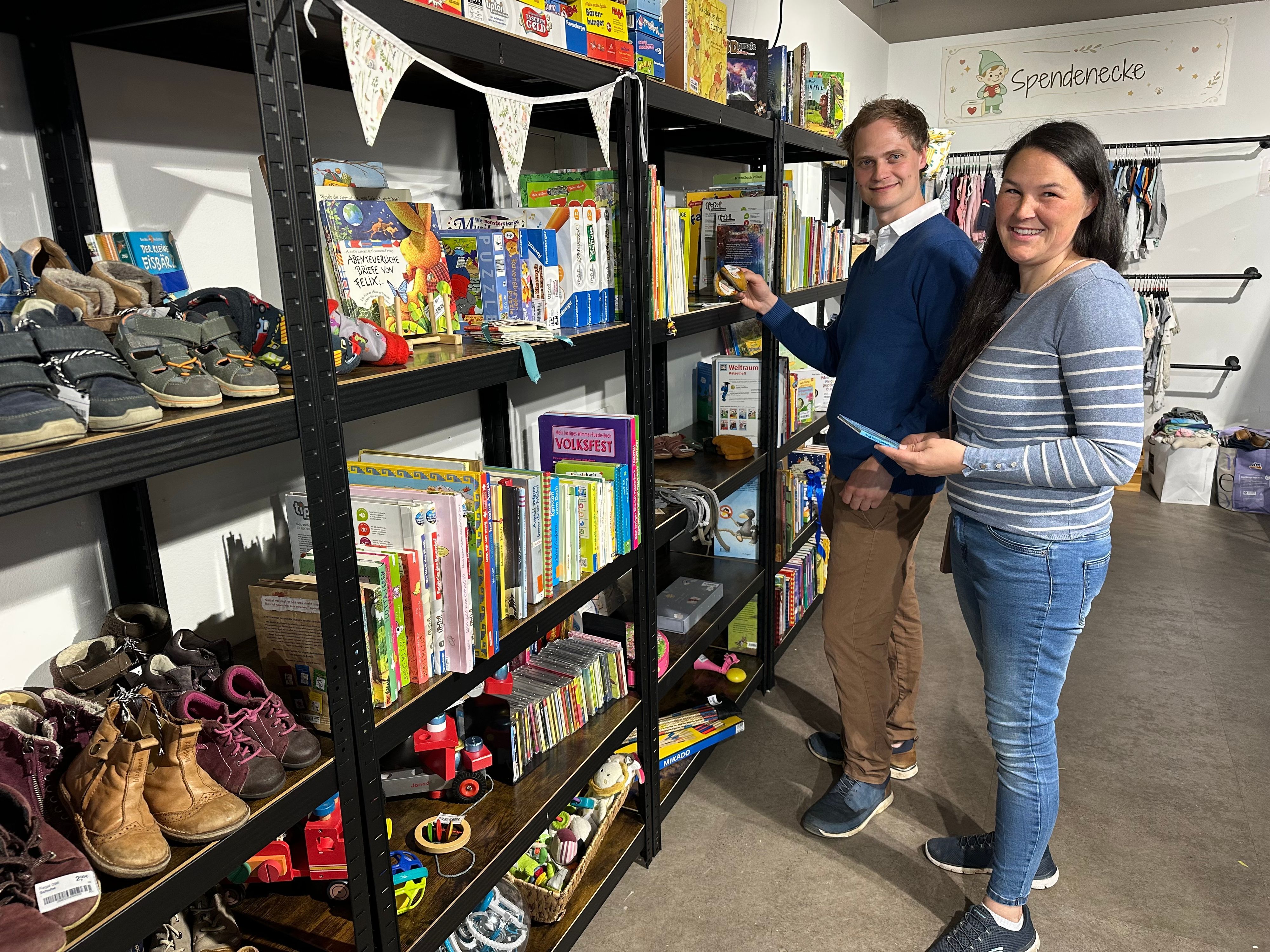 Katharina und Simon Theiß an einem Mietregal im Verkaufsraum der Wichtelwiese in Sankt Augustin.
