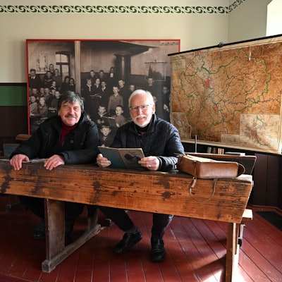 Michael Kamp (l.) und Werner Hütt, Geschäftsführer des Vereins der Freunde und Förderer des Freilichtmuseums Lindlar in einer Schulbank der ehemaligen Elementarschule Hermesdorf.