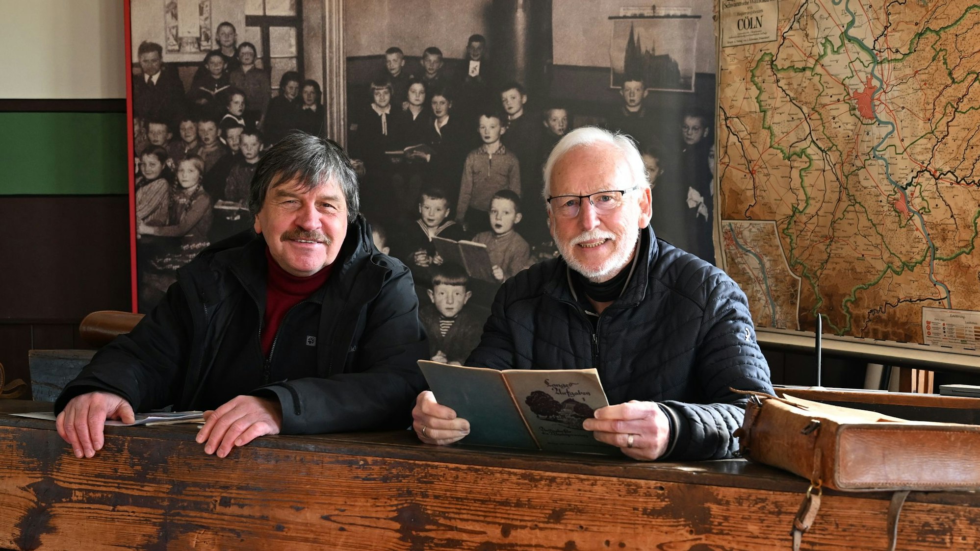 Michael Kamp (l.) und Werner Hütt, Geschäftsführer des Vereins der Freunde und Förderer des Freilichtmuseums Lindlar in einer Schulbank der ehemaligen Elementarschule Hermesdorf.