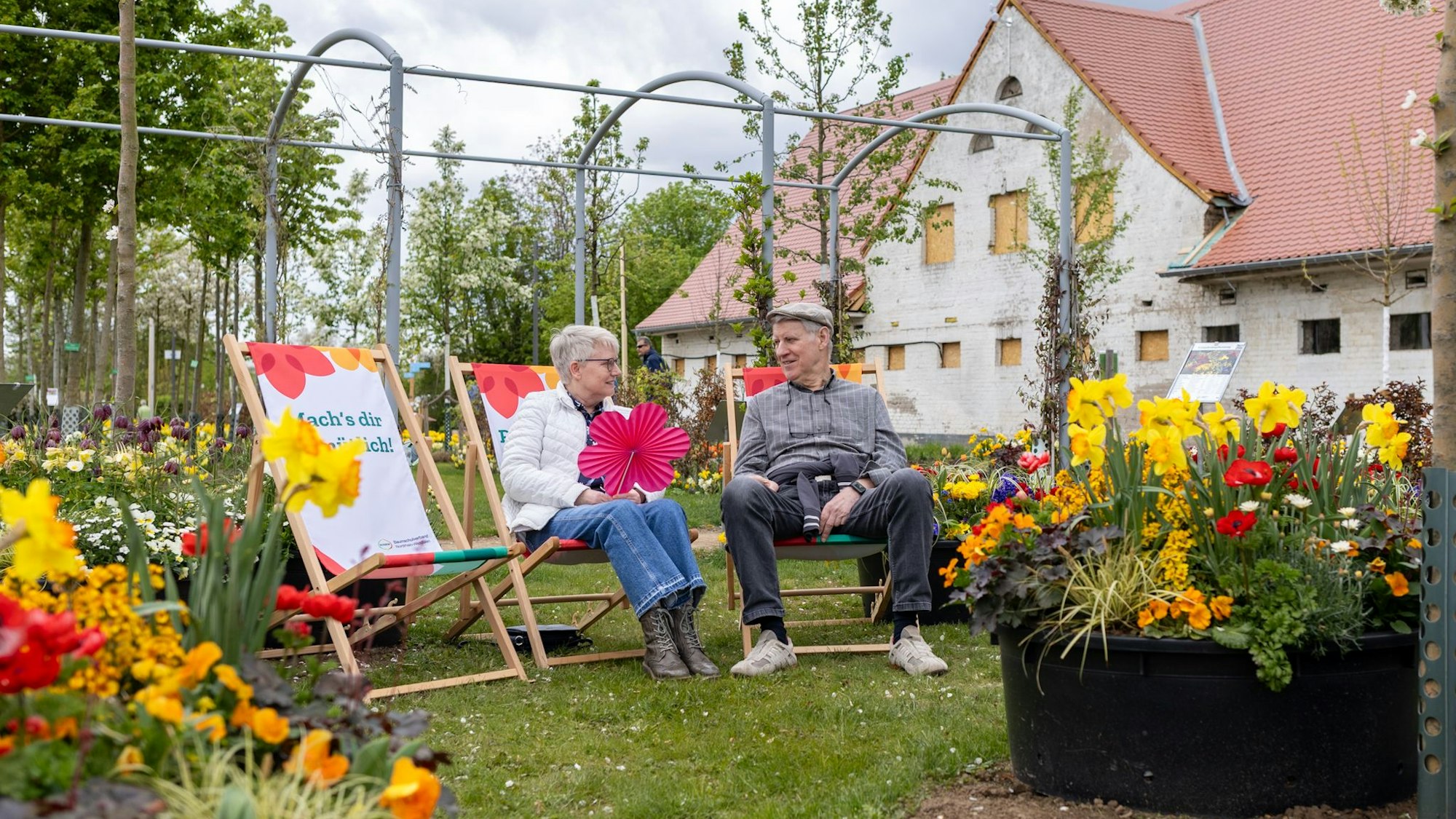 Zwei Senioren sitzen jeweils auf einem Liegestuhl und unterhalten sich.