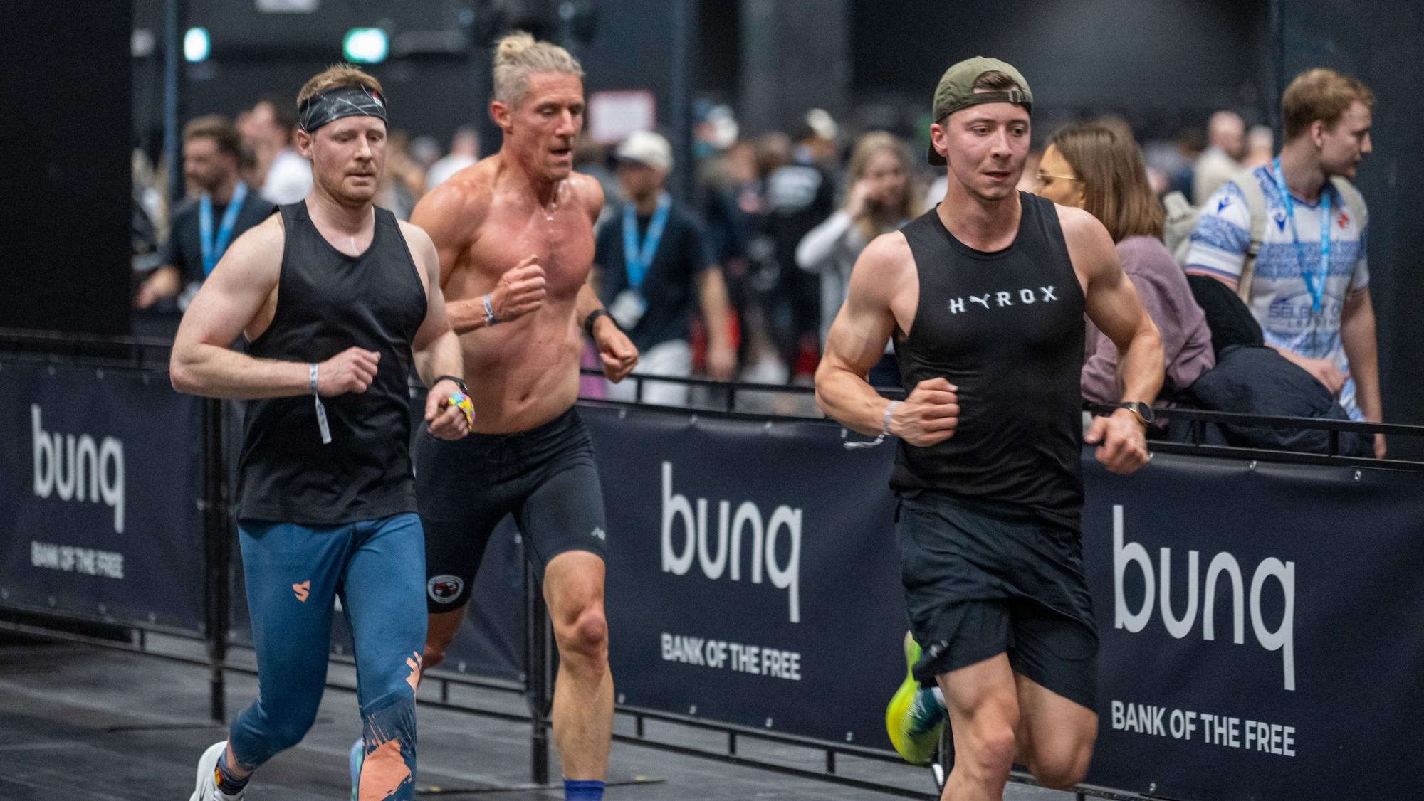 Drei Männer während einer von acht Laufrunden beim Hyrox in Köln.