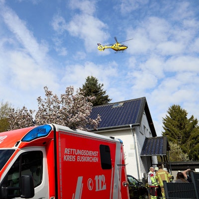 Der ADAC-Rettungshubschrauber fliegt über das Haus, davor ein Rettungswagen und Einsatzkräfte.