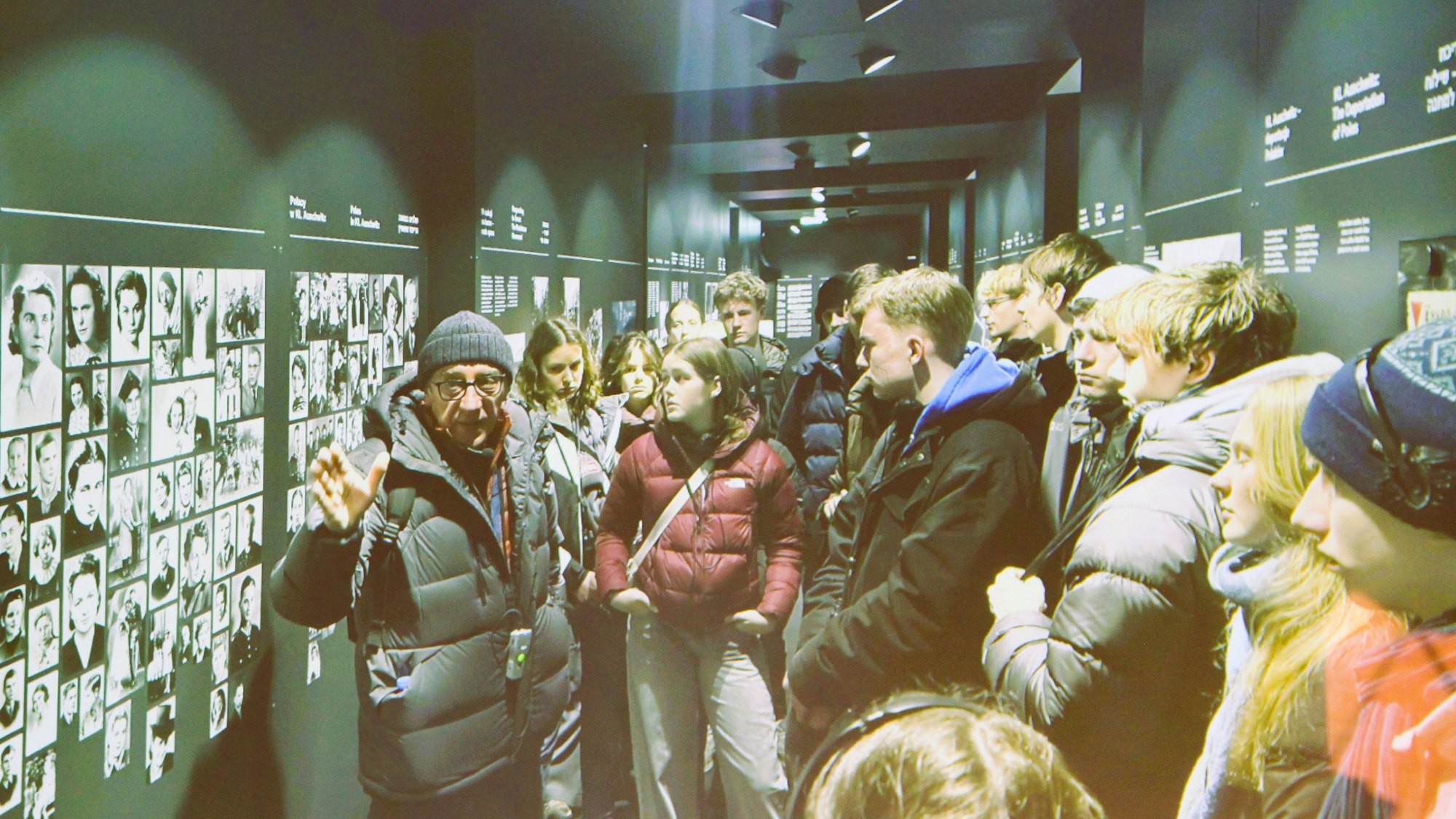 Schüler stehen vor einer Wand mit Schwarz-Weiß-Fotos.